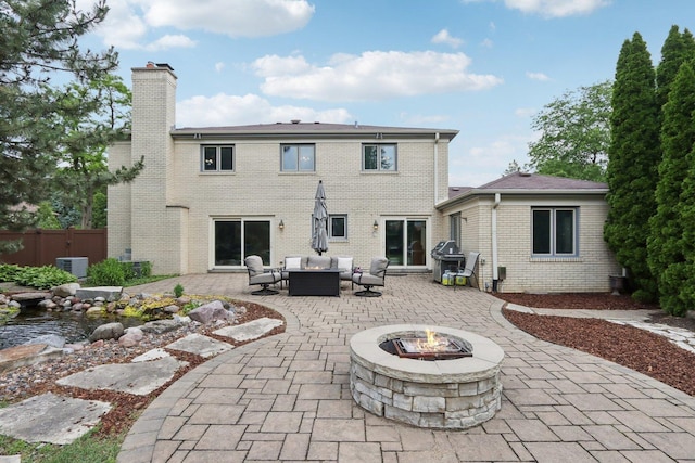 102 E Adelia St, Elmhurst, IL 60126 - back of property featuring an outdoor living space with a fire pit, a chimney, a patio area, and brick siding