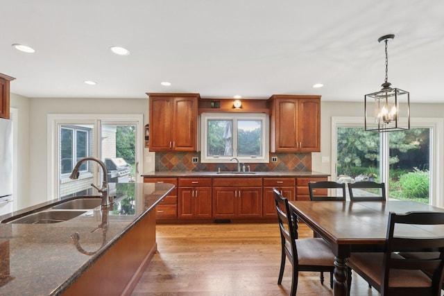 102 E Adelia St, Elmhurst, IL 60126 - kitchen featuring light wood-type flooring, dark stone countertops, backsplash, brown cabinets, and recessed lighting