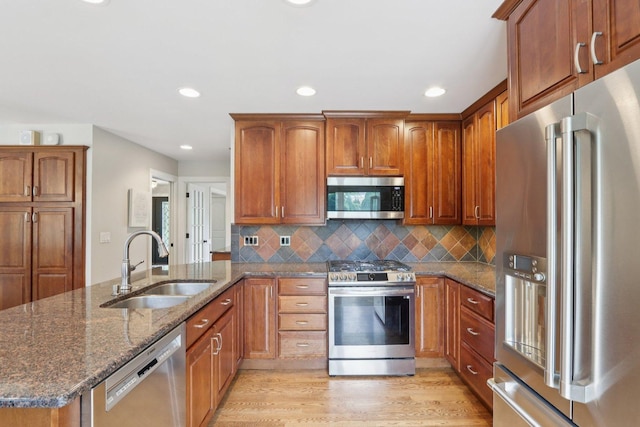102 E Adelia St, Elmhurst, IL 60126 - kitchen with stainless steel appliances, dark stone counters, brown cabinets, a peninsula, and recessed lighting