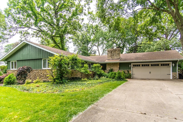 2458 E Cass St, Joliet, IL 60432 - view of front of house featuring stone siding, a chimney, an attached garage, concrete driveway, and a front yard