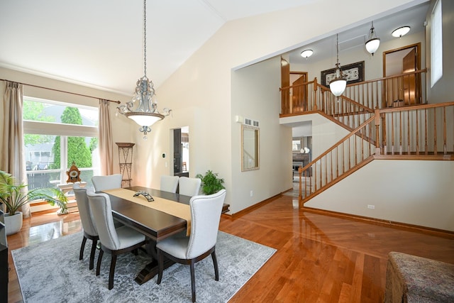 678 Larch Dr, Carol Stream, IL 60188 - dining area with stairway, a chandelier, wood finished floors, and high vaulted ceiling
