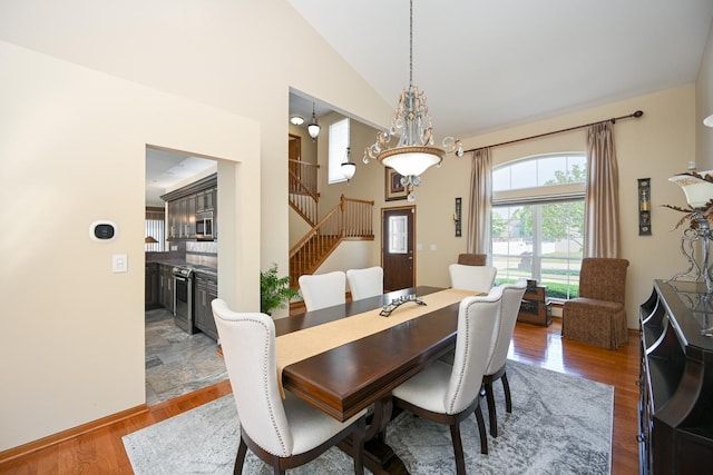 678 Larch Dr, Carol Stream, IL 60188 - dining room with stairway, wood finished floors, high vaulted ceiling, and a chandelier