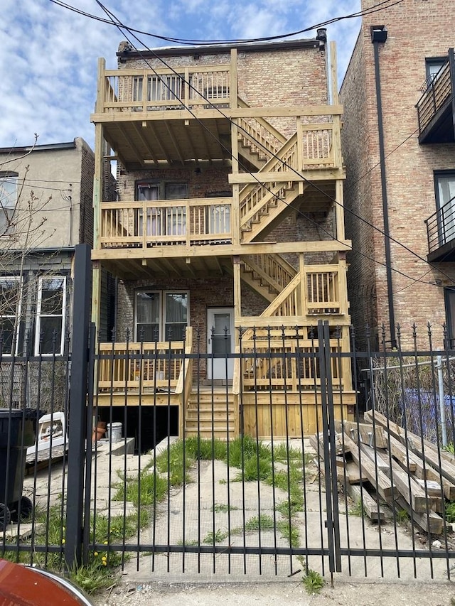 2735 W Washington Blvd, Chicago, IL 60612 - rear view of property with a fenced front yard, brick siding, stairway, a gate, and a balcony