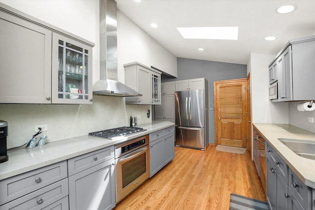 4770 Woodcliff Ln, Palatine, IL 60067 - kitchen with stainless steel appliances, gray cabinetry, wall chimney exhaust hood, a skylight, and lofted ceiling