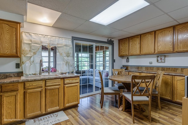 161 Olympic Dr, Bolingbrook, IL 60440 - kitchen with brown cabinets, light wood-type flooring, a paneled ceiling, and dark countertops
