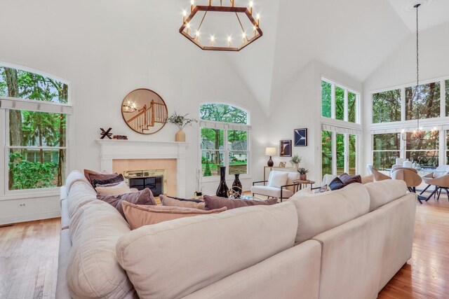 1700 Cornell Ct, Lake Forest, IL 60045 - living room with high vaulted ceiling, a chandelier, light wood finished floors, and a tiled fireplace