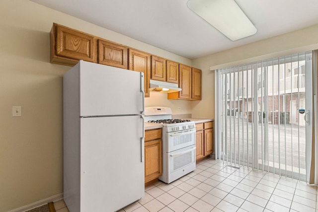 9207 E Prairie Rd, Evanston, IL 60203 - kitchen featuring white appliances, under cabinet range hood, light countertops, and light tile patterned floors