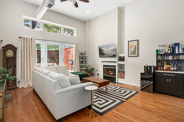 1217 N Greenview Ave Unit G, Chicago, IL 60642 - living area featuring a high ceiling, bar, ceiling fan, light wood-style flooring, and a glass covered fireplace