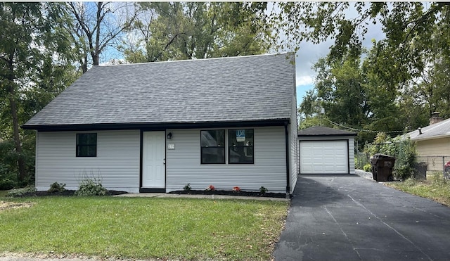 view of front of home featuring a shingled roof, an outbuilding, driveway, and a front lawn