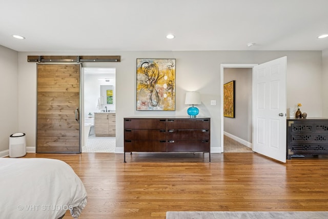 821 Sandstone Dr, Libertyville, IL 60048 - bedroom with wood finished floors, a barn door, recessed lighting, and connected bathroom