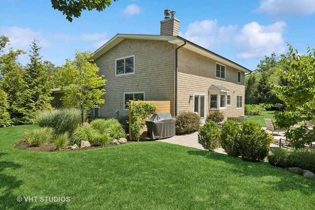 821 Sandstone Dr, Libertyville, IL 60048 - back of property featuring a yard, a patio area, and a chimney