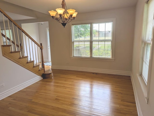 11360 195th St, Mokena, IL 60448 - unfurnished dining area with a chandelier, wood finished floors, and stairway