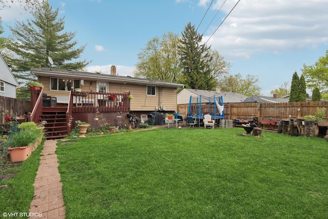 2110 Hermon Ave, Zion, IL 60099 - rear view of property featuring a fenced backyard, a wooden deck, a trampoline, stairs, and a chimney
