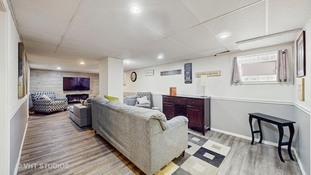 7525 N Overhill Ave, Chicago, IL 60631 - living room featuring light wood-type flooring, a paneled ceiling, wood walls, and a glass covered fireplace