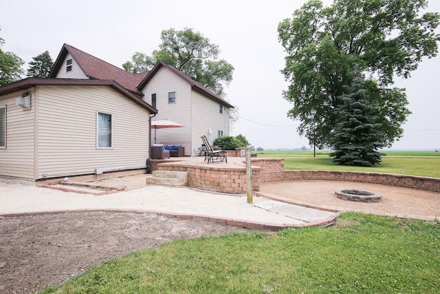382 Keigwin Rd, Walnut, IL 61376 - rear view of house featuring a fire pit, a patio, and a lawn