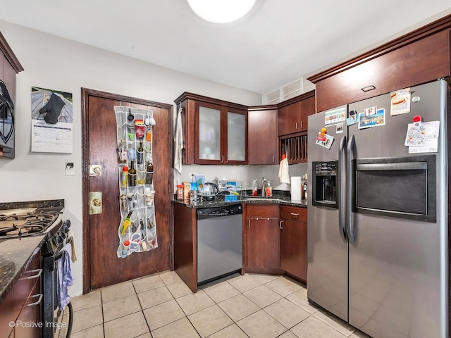 2118 W N Ave Unit Bs, Chicago, IL 60647 - kitchen featuring stainless steel appliances, light tile patterned floors, dark stone countertops, and glass insert cabinets