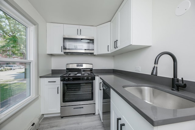 123 N W St, Wheaton, IL 60187 - kitchen with appliances with stainless steel finishes, dark countertops, white cabinets, and light wood-type flooring