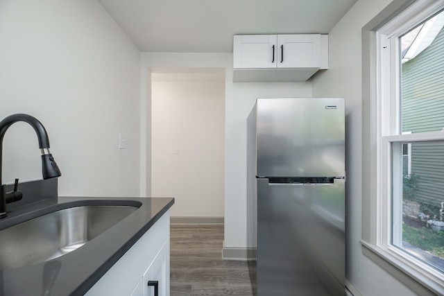 123 N W St, Wheaton, IL 60187 - kitchen with freestanding refrigerator, dark wood-style flooring, dark countertops, white cabinetry, and a baseboard heating unit