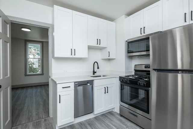 123 N W St, Wheaton, IL 60187 - kitchen featuring appliances with stainless steel finishes, light wood-type flooring, light countertops, and white cabinets