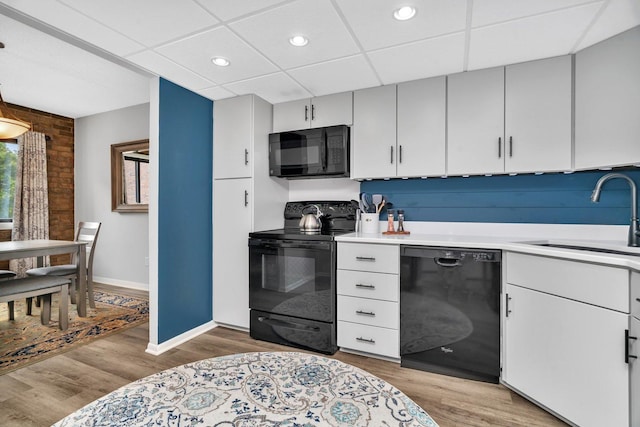 1422 Woodbridge Rd Unit 2E, Joliet, IL 60436 - kitchen featuring black appliances, light countertops, light wood-type flooring, a drop ceiling, and recessed lighting