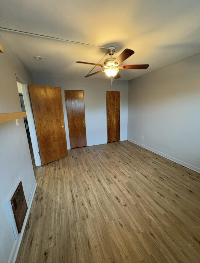 1205 N Harlem Ave Unit 6, Oak Park, IL 60302 - unfurnished bedroom with wood finished floors, two closets, and a ceiling fan