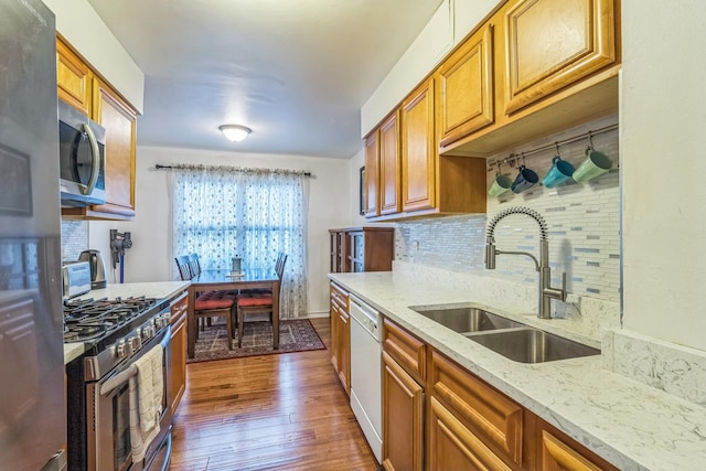 817 Hibbard Rd Unit D, Wilmette, IL 60091 - kitchen with appliances with stainless steel finishes, decorative backsplash, dark wood-style floors, brown cabinets, and light stone countertops