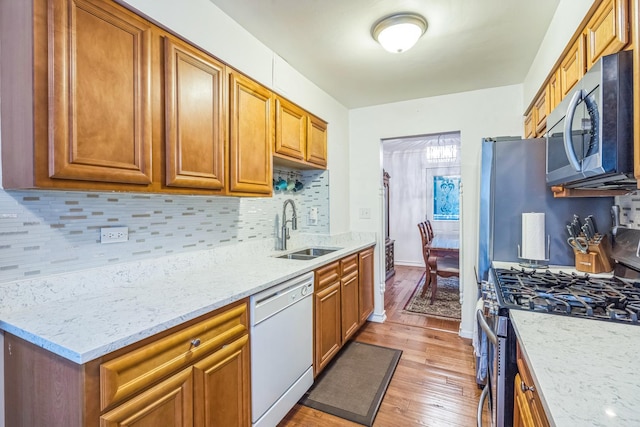 817 Hibbard Rd Unit D, Wilmette, IL 60091 - kitchen with stainless steel appliances, light wood-type flooring, decorative backsplash, light stone countertops, and brown cabinets
