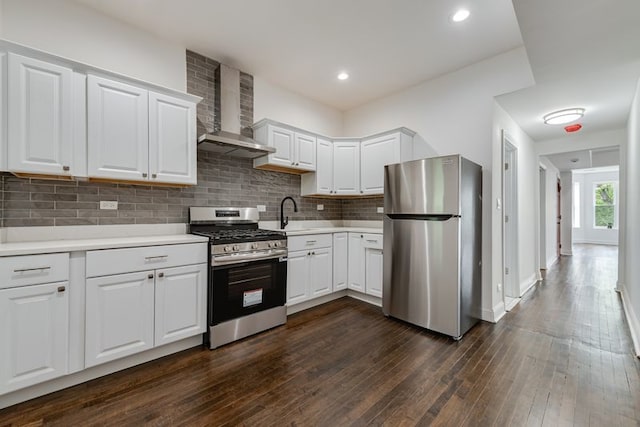 4047 W Adams St, Chicago, IL 60624 - kitchen featuring appliances with stainless steel finishes, wall chimney range hood, light countertops, decorative backsplash, and white cabinetry