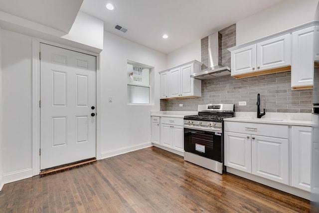 4047 W Adams St, Chicago, IL 60624 - kitchen with stainless steel gas range, wall chimney exhaust hood, light countertops, dark wood-style floors, and decorative backsplash