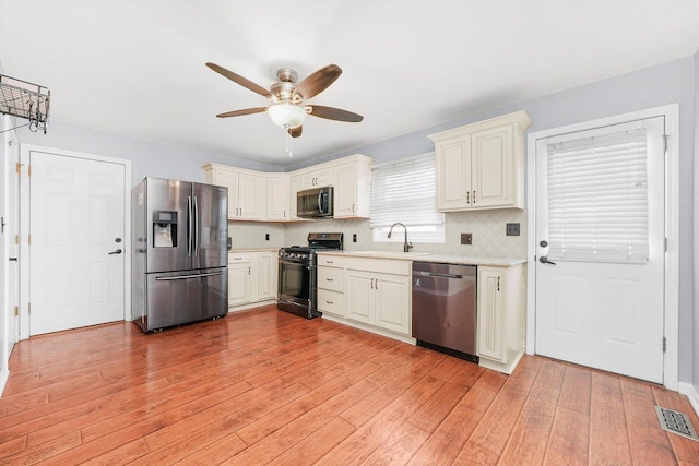 13659 W Cedarbend Dr, Homer Glen, IL 60491 - kitchen featuring stainless steel appliances, light countertops, a ceiling fan, tasteful backsplash, and light wood-style flooring