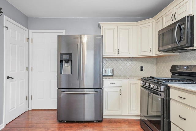 13659 W Cedarbend Dr, Homer Glen, IL 60491 - kitchen featuring black appliances, cream cabinets, wood finished floors, and tasteful backsplash