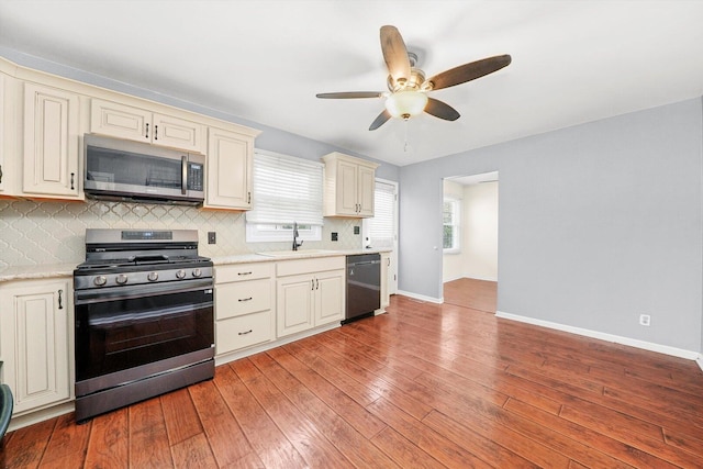13659 W Cedarbend Dr, Homer Glen, IL 60491 - kitchen with appliances with stainless steel finishes, cream cabinets, a ceiling fan, decorative backsplash, and light wood-type flooring