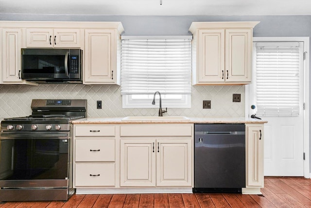13659 W Cedarbend Dr, Homer Glen, IL 60491 - kitchen featuring appliances with stainless steel finishes, cream cabinets, hardwood / wood-style flooring, and decorative backsplash
