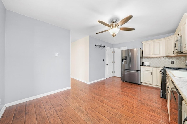 13659 W Cedarbend Dr, Homer Glen, IL 60491 - kitchen with stainless steel appliances, a ceiling fan, cream cabinets, tasteful backsplash, and light wood-style floors