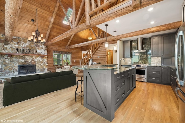 723 N River Rd, Algonquin, IL 60102 - kitchen featuring appliances with stainless steel finishes, wall chimney range hood, dark stone counters, open floor plan, and gray cabinets
