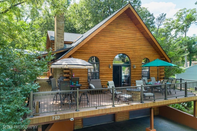 723 N River Rd, Algonquin, IL 60102 - back of property with outdoor dining space, a wooden deck, a chimney, and log exterior