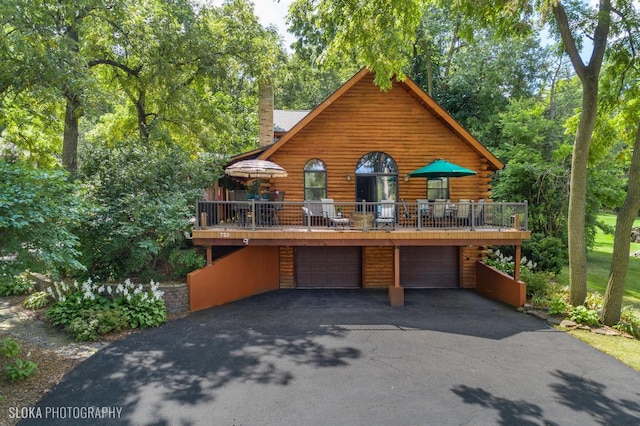 723 N River Rd, Algonquin, IL 60102 - cabin featuring log siding, a garage, a chimney, driveway, and a wooden deck