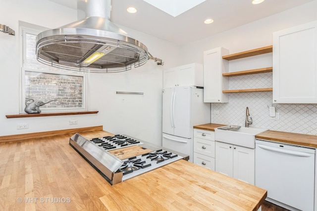 1133 N Spaulding Ave, Chicago, IL 60651 - kitchen with butcher block countertops, white appliances, island range hood, a skylight, and white cabinetry
