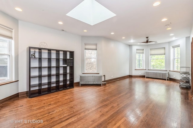 1133 N Spaulding Ave, Chicago, IL 60651 - empty room featuring radiator, recessed lighting, wood finished floors, a ceiling fan, and a skylight