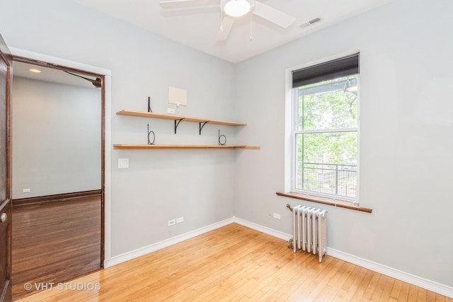 1133 N Spaulding Ave, Chicago, IL 60651 - unfurnished room featuring radiator heating unit, hardwood / wood-style flooring, and a ceiling fan