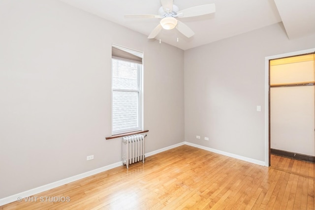 1133 N Spaulding Ave, Chicago, IL 60651 - unfurnished bedroom with radiator, light wood-style flooring, ceiling fan, and a closet