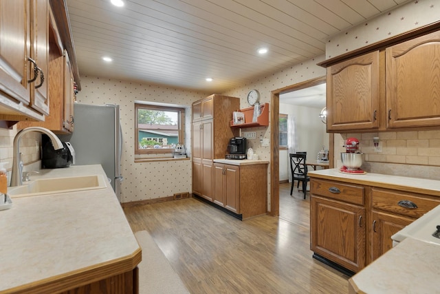 525 Palmer Ave, Aurora, IL 60506 - kitchen featuring wallpapered walls, light wood-style flooring, light countertops, tasteful backsplash, and brown cabinets