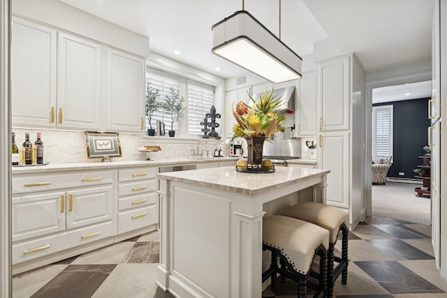 219 E Lake Shore Dr Unit 8C, Chicago, IL 60611 - kitchen with white cabinets, a kitchen bar, backsplash, a kitchen island, and recessed lighting