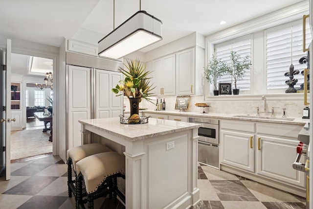 219 E Lake Shore Dr Unit 8C, Chicago, IL 60611 - kitchen with white cabinets, a center island, a kitchen bar, a chandelier, and recessed lighting