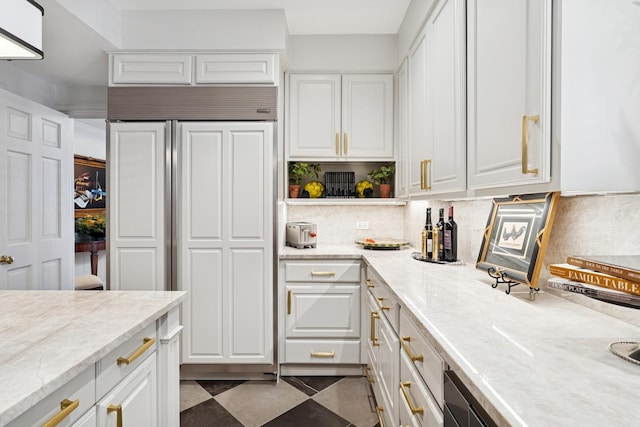 219 E Lake Shore Dr Unit 8C, Chicago, IL 60611 - kitchen with paneled built in fridge, white cabinetry, decorative backsplash, and light stone countertops