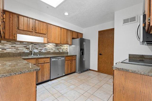 5357 Winding Creek Dr Unit 5357, Rockford, IL 61114 - kitchen featuring appliances with stainless steel finishes, brown cabinetry, backsplash, light tile patterned flooring, and recessed lighting