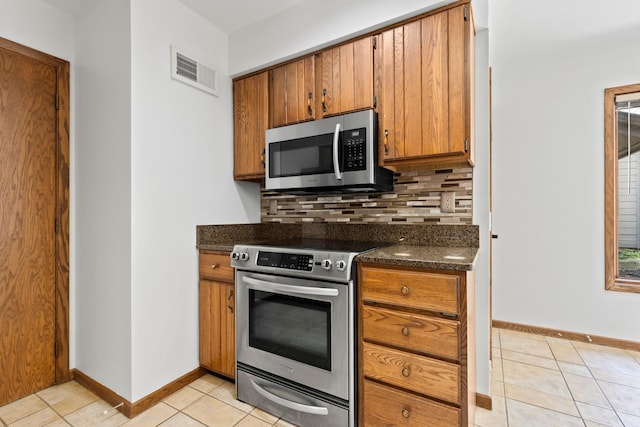5357 Winding Creek Dr Unit 5357, Rockford, IL 61114 - kitchen featuring appliances with stainless steel finishes, light tile patterned flooring, backsplash, and brown cabinetry