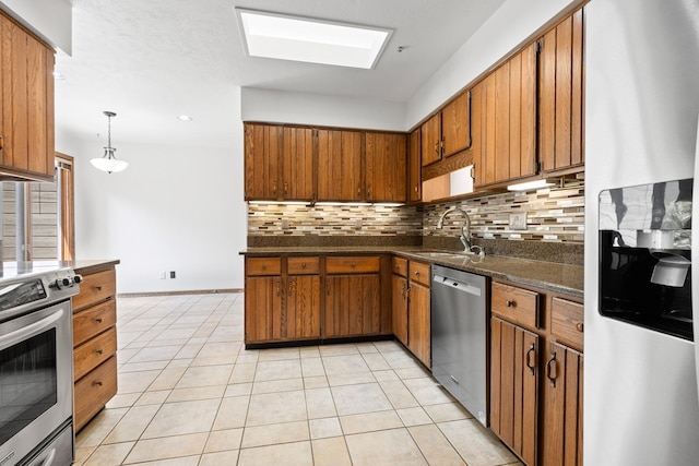 5357 Winding Creek Dr Unit 5357, Rockford, IL 61114 - kitchen featuring appliances with stainless steel finishes, dark countertops, brown cabinets, tasteful backsplash, and light tile patterned flooring