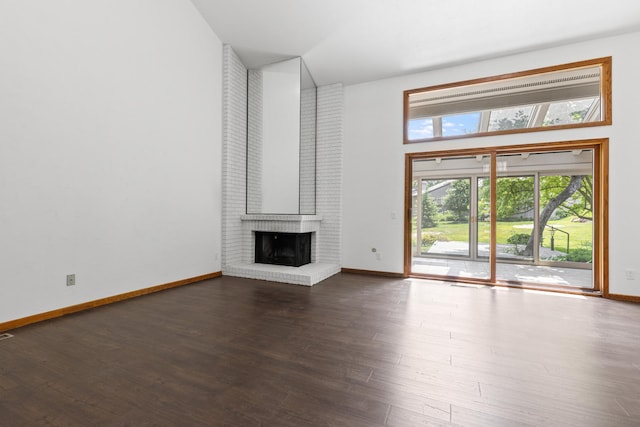 5357 Winding Creek Dr Unit 5357, Rockford, IL 61114 - unfurnished living room featuring a brick fireplace, dark wood-style flooring, and a towering ceiling