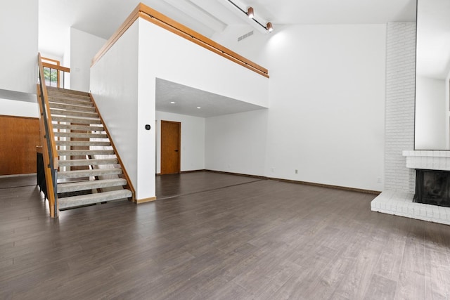 5357 Winding Creek Dr Unit 5357, Rockford, IL 61114 - unfurnished living room featuring beam ceiling, stairs, wood finished floors, a fireplace, and high vaulted ceiling